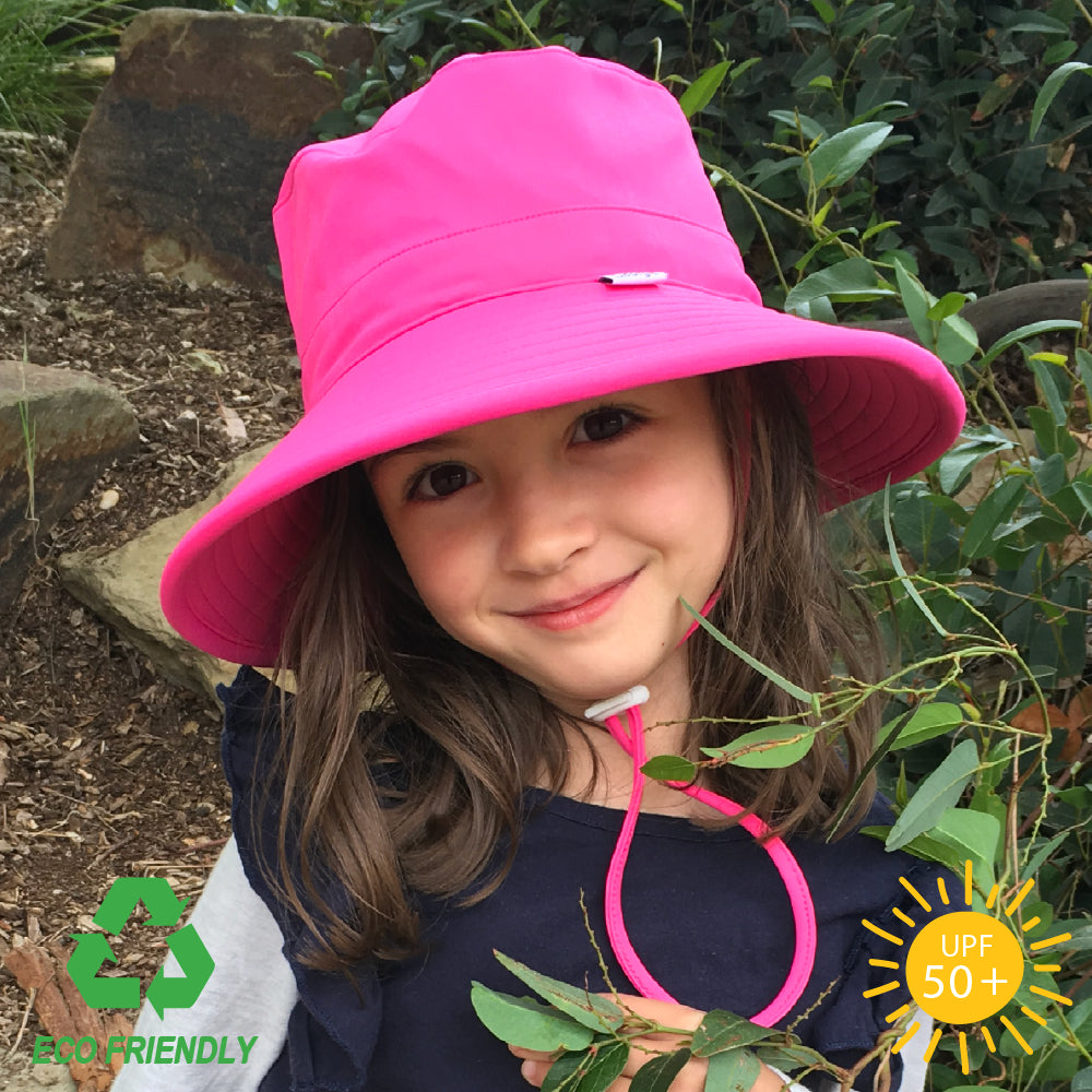 Kids bucket sun hat with playful pink fabric, wide anti-flop brim, and breakaway chin strap, crafted from recycled nylon elastane fabric