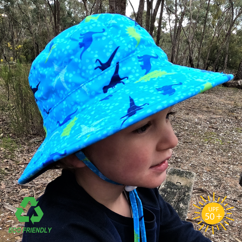 Children’s bucket sun hat with playful dinosaur pattern, wide brim for sun protection, breakaway chin strap, and soft recycled rPET fabric